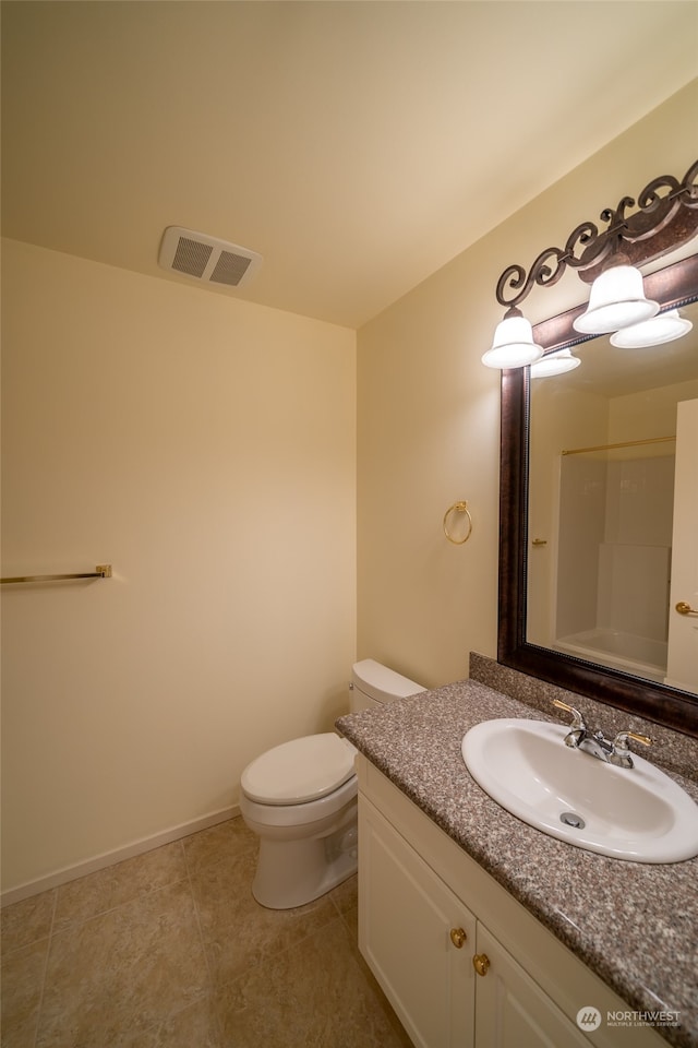 bathroom with tile floors, oversized vanity, and toilet