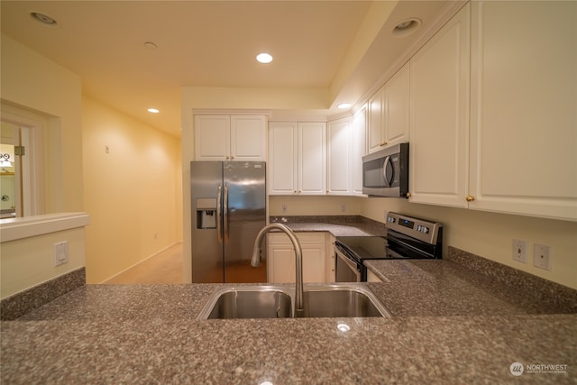 kitchen featuring stainless steel appliances, white cabinetry, and sink