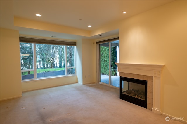 unfurnished living room featuring a fireplace and light colored carpet