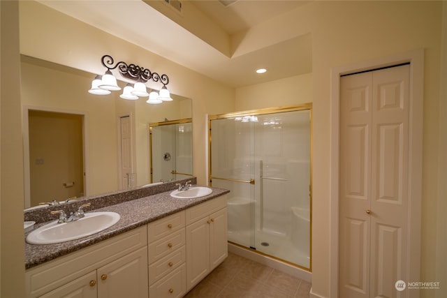 bathroom featuring tile flooring, dual sinks, walk in shower, and vanity with extensive cabinet space