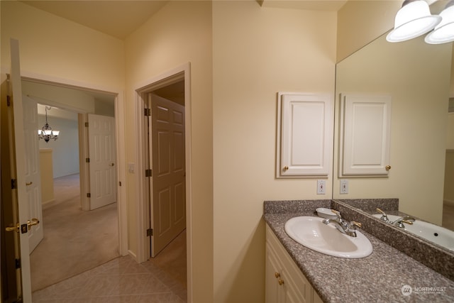 bathroom featuring an inviting chandelier, tile floors, and vanity with extensive cabinet space