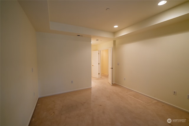 carpeted spare room with a tray ceiling