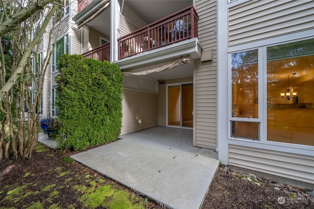 view of exterior entry featuring a balcony and a patio area