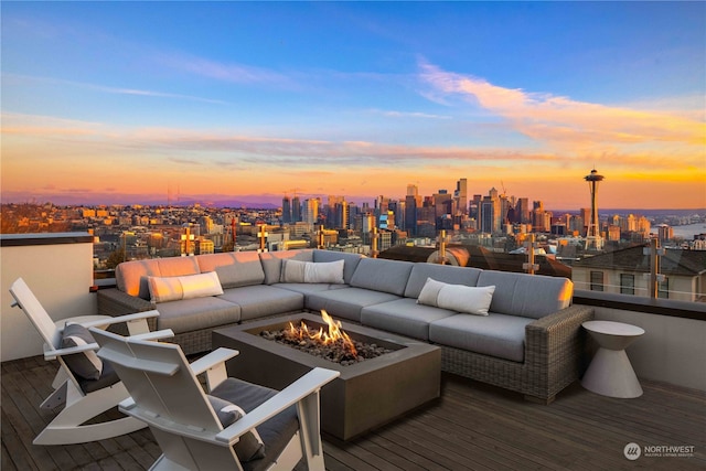 deck at dusk featuring an outdoor fire pit