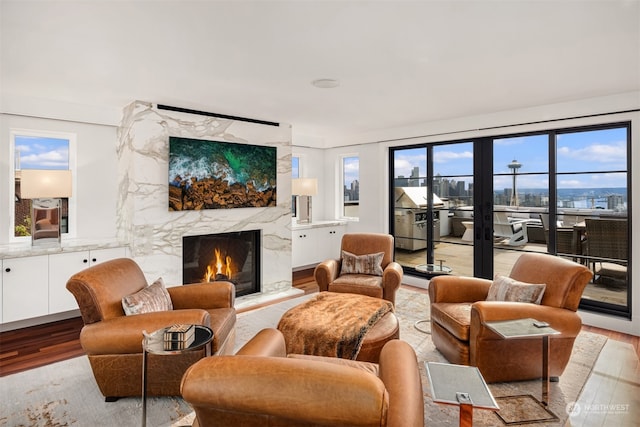 living room featuring light wood-type flooring and a high end fireplace