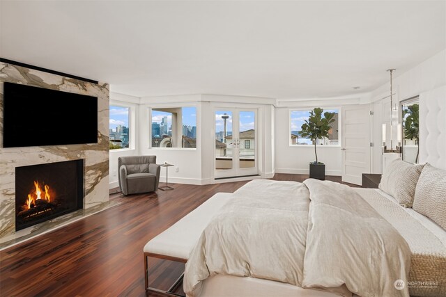 bedroom featuring multiple windows, dark wood-type flooring, and a premium fireplace