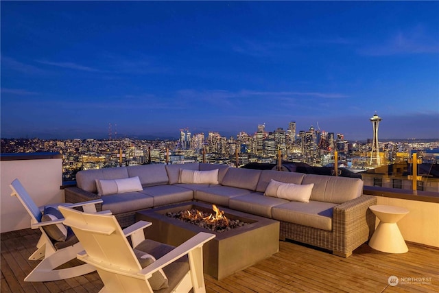 deck at dusk with an outdoor living space with a fire pit