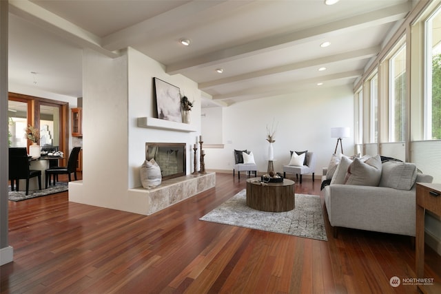 living room featuring a fireplace, beamed ceiling, and dark hardwood / wood-style flooring