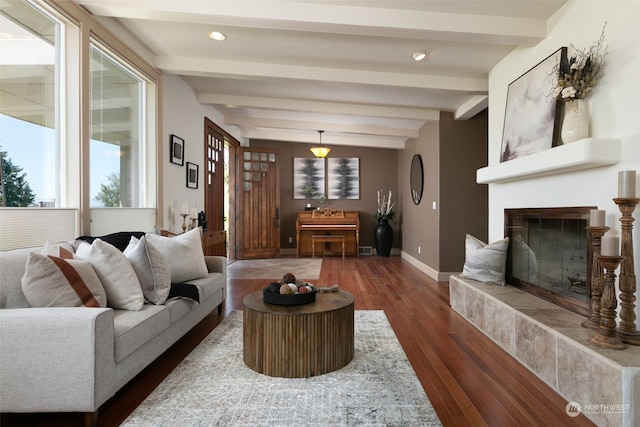 living room with beamed ceiling, dark hardwood / wood-style flooring, and a tile fireplace