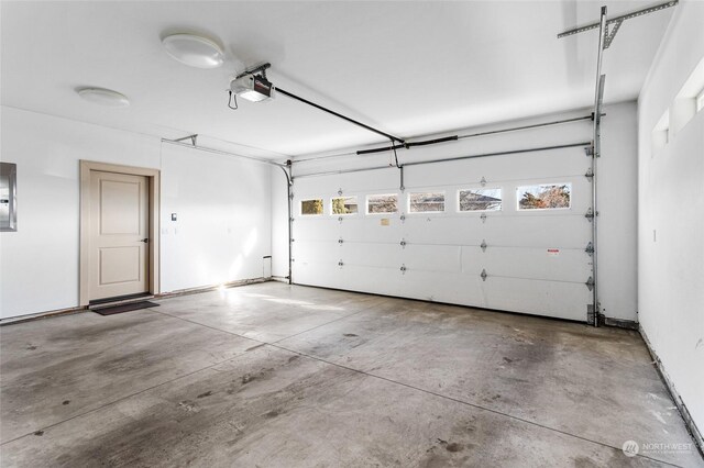 garage featuring electric panel and a garage door opener