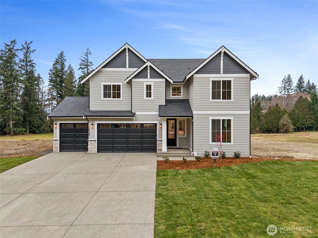 craftsman inspired home with a garage, a shingled roof, concrete driveway, stone siding, and a front yard