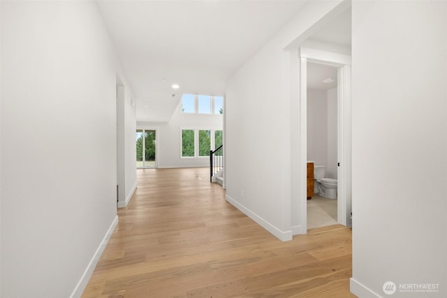 corridor with light wood finished floors, stairway, baseboards, and recessed lighting