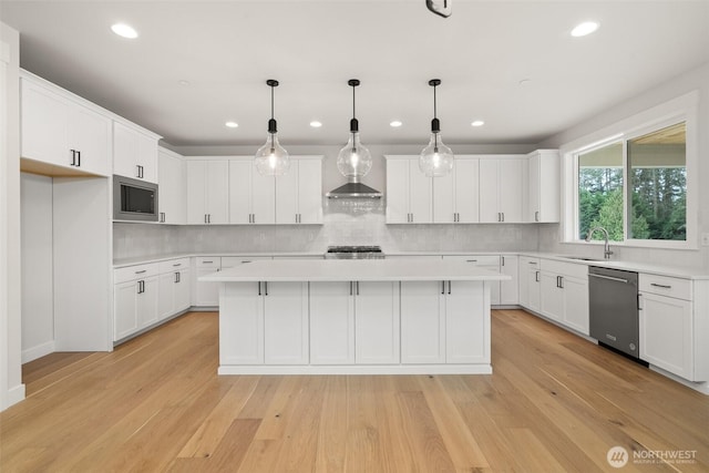 kitchen featuring light countertops, appliances with stainless steel finishes, white cabinets, and a center island