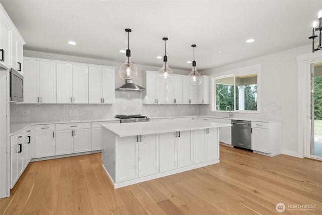 kitchen featuring a center island, light countertops, dishwasher, and white cabinetry