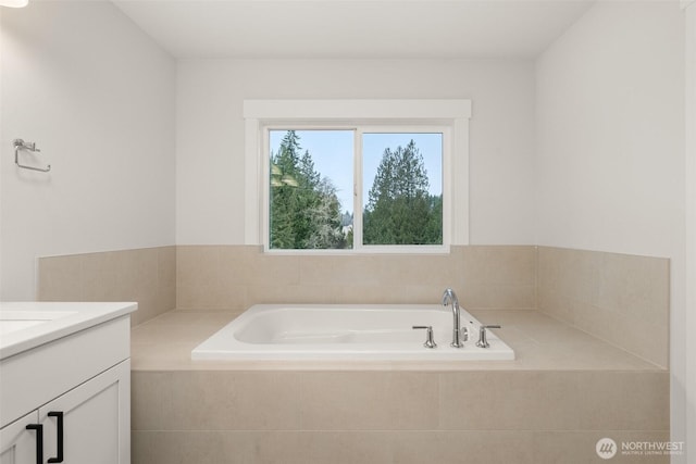 bathroom featuring a garden tub and vanity