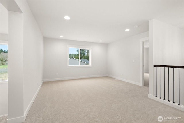 spare room with baseboards, recessed lighting, and light colored carpet