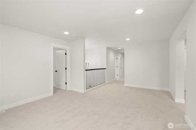 spare room with baseboards, light colored carpet, and recessed lighting