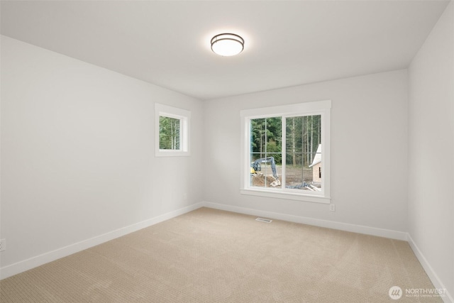 carpeted empty room with visible vents and baseboards