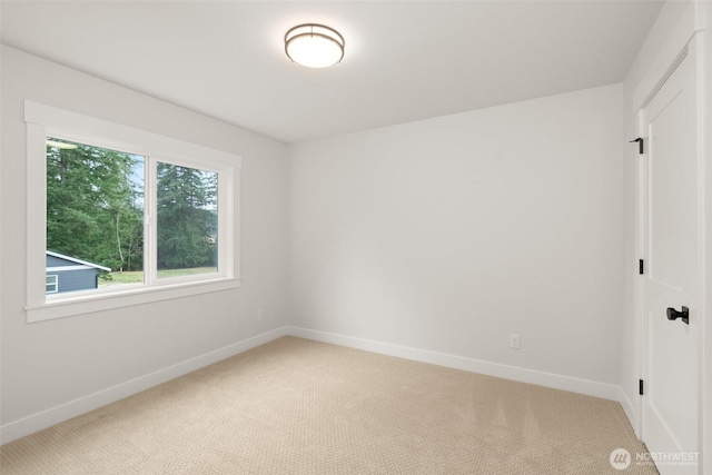 empty room featuring carpet floors and baseboards