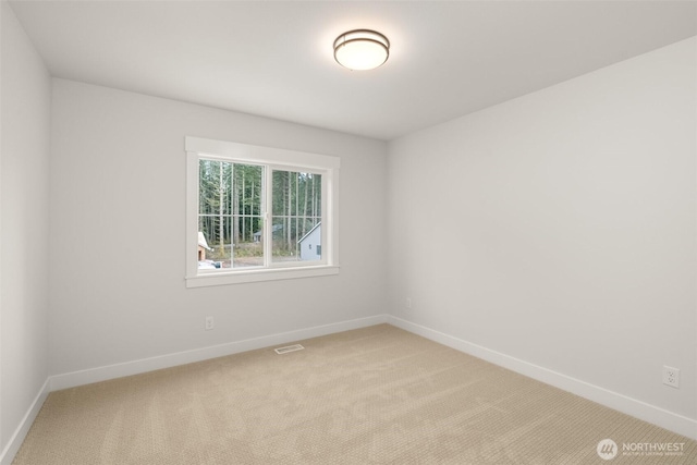 empty room featuring visible vents, light carpet, and baseboards