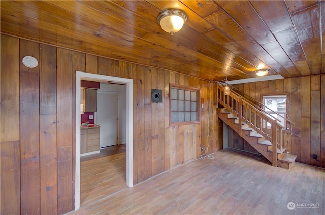 spare room featuring wooden ceiling, wooden walls, and light hardwood / wood-style flooring