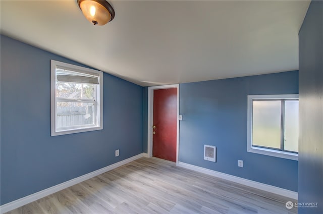 unfurnished room featuring light wood-type flooring and vaulted ceiling