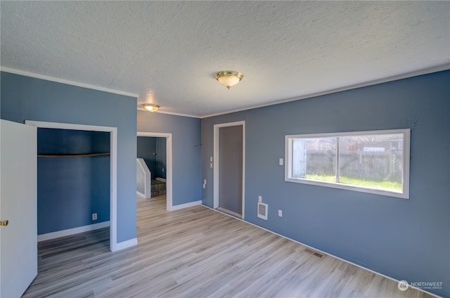 unfurnished bedroom featuring light wood-type flooring and a textured ceiling