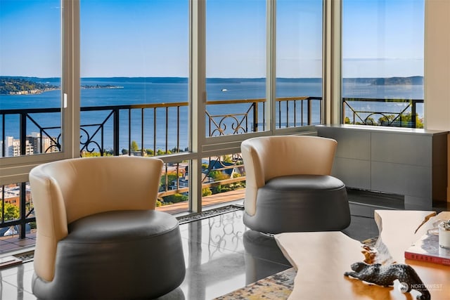 sunroom featuring a water view