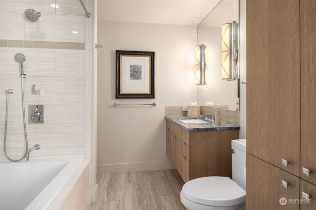 full bathroom with toilet, tiled shower / bath, large vanity, and wood-type flooring