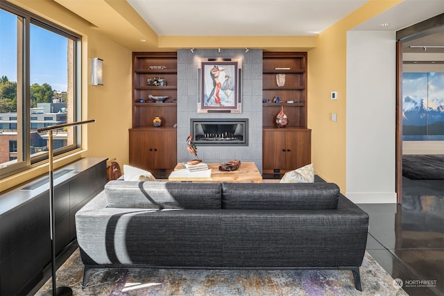 living room with dark tile floors and a tiled fireplace