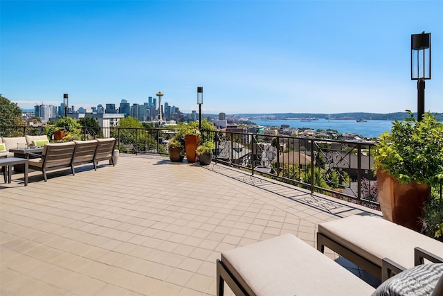 view of patio with a water view, an outdoor hangout area, and a balcony