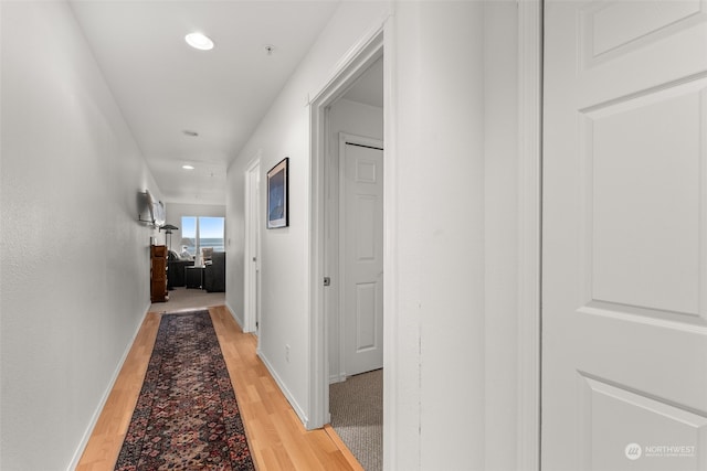 hallway with light hardwood / wood-style floors