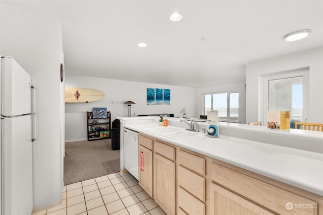 kitchen with light brown cabinets, sink, white appliances, and light tile floors