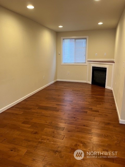 unfurnished living room with dark wood-type flooring