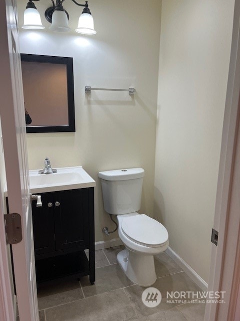 bathroom with tile flooring, toilet, and vanity