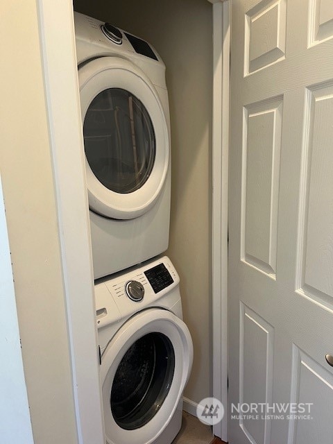 washroom featuring stacked washer / drying machine