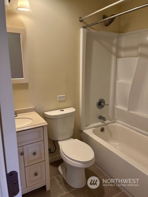 full bathroom with tile floors, large vanity, toilet, and tub / shower combination