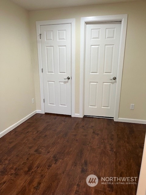 unfurnished bedroom with dark hardwood / wood-style floors