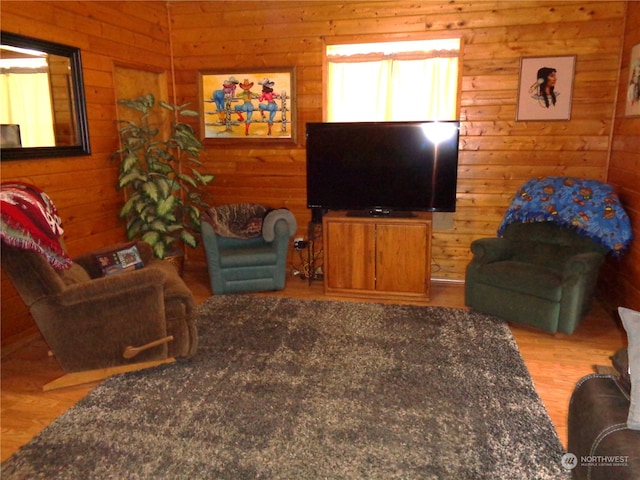 living room featuring light wood-type flooring and wood walls