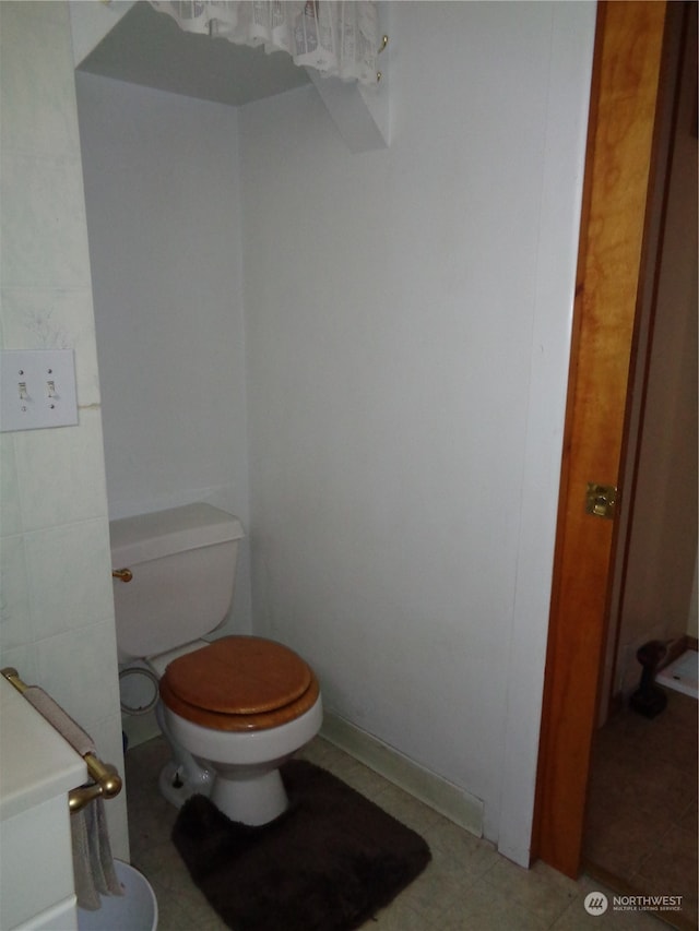 bathroom featuring toilet and tile floors