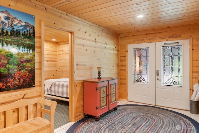 entryway with french doors, light tile flooring, and wooden walls