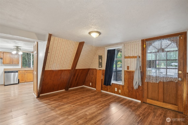 entryway featuring a textured ceiling, wooden walls, and light hardwood / wood-style flooring