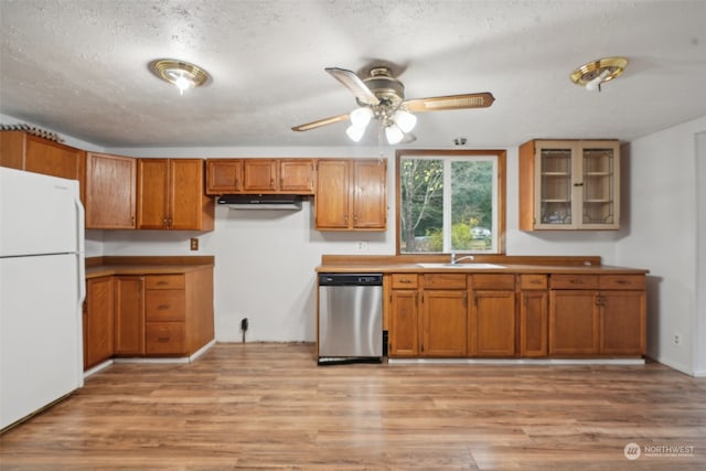 kitchen featuring dishwasher, white fridge, light hardwood / wood-style floors, and sink