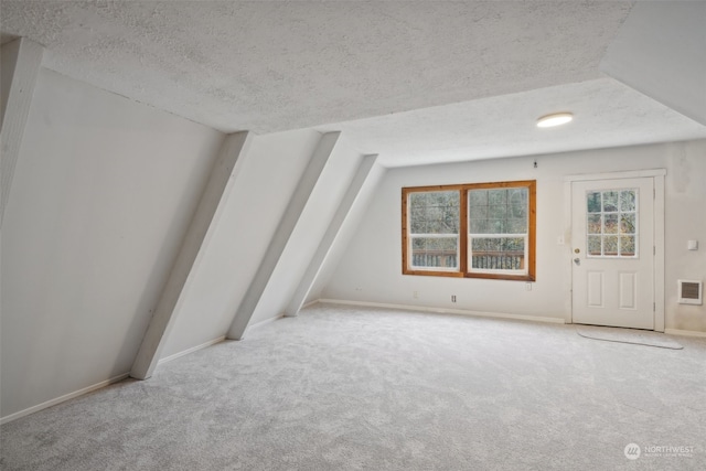 bonus room featuring a textured ceiling, light carpet, and vaulted ceiling