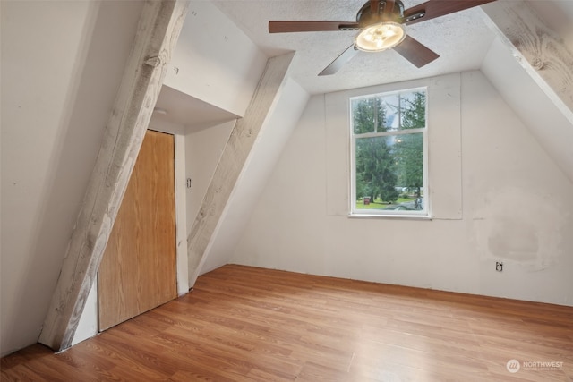 additional living space featuring a textured ceiling, light hardwood / wood-style floors, ceiling fan, and lofted ceiling