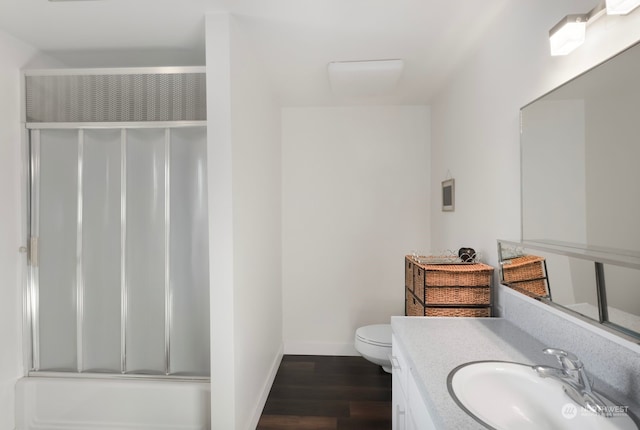 bathroom with toilet, large vanity, and wood-type flooring