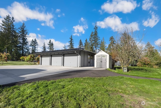 ranch-style house with a front lawn, an outdoor structure, and a garage