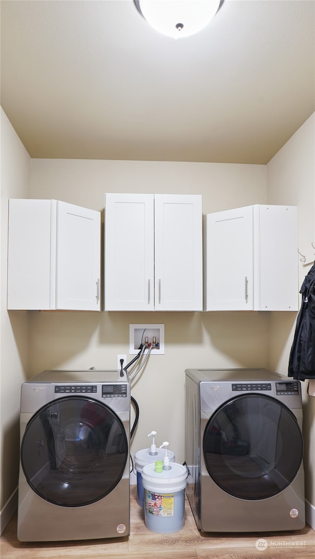 washroom featuring light hardwood / wood-style flooring, washer hookup, and cabinets