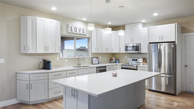 kitchen with appliances with stainless steel finishes, white cabinets, and a center island