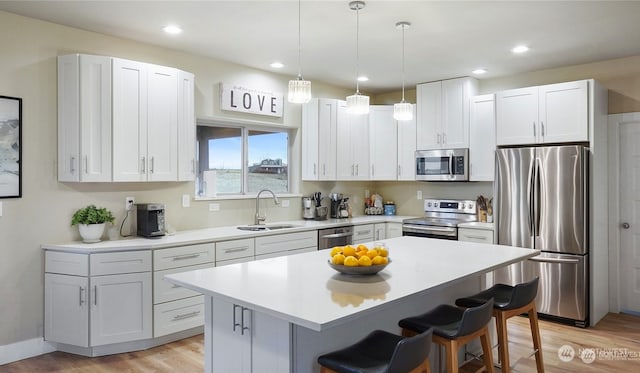 kitchen featuring appliances with stainless steel finishes, white cabinetry, and a kitchen bar